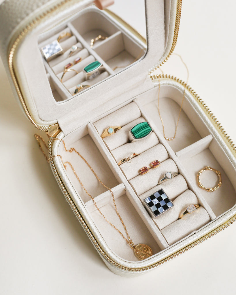 assorted pieces of jewelry from rings, necklaces, earrings, and pendants in a traveling jewelry box. 
